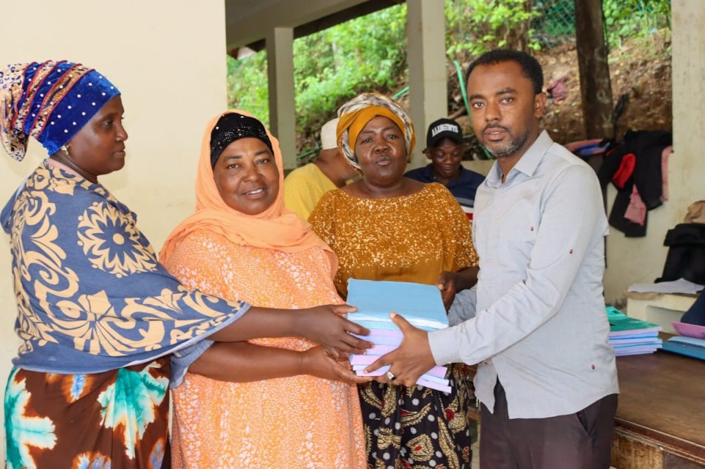 Rukia Pamba and other members of Pweza Women’s Group receive manuals and other documents for managing their community projects. They will receive continuous mentorship from county technical officers and field assistants.