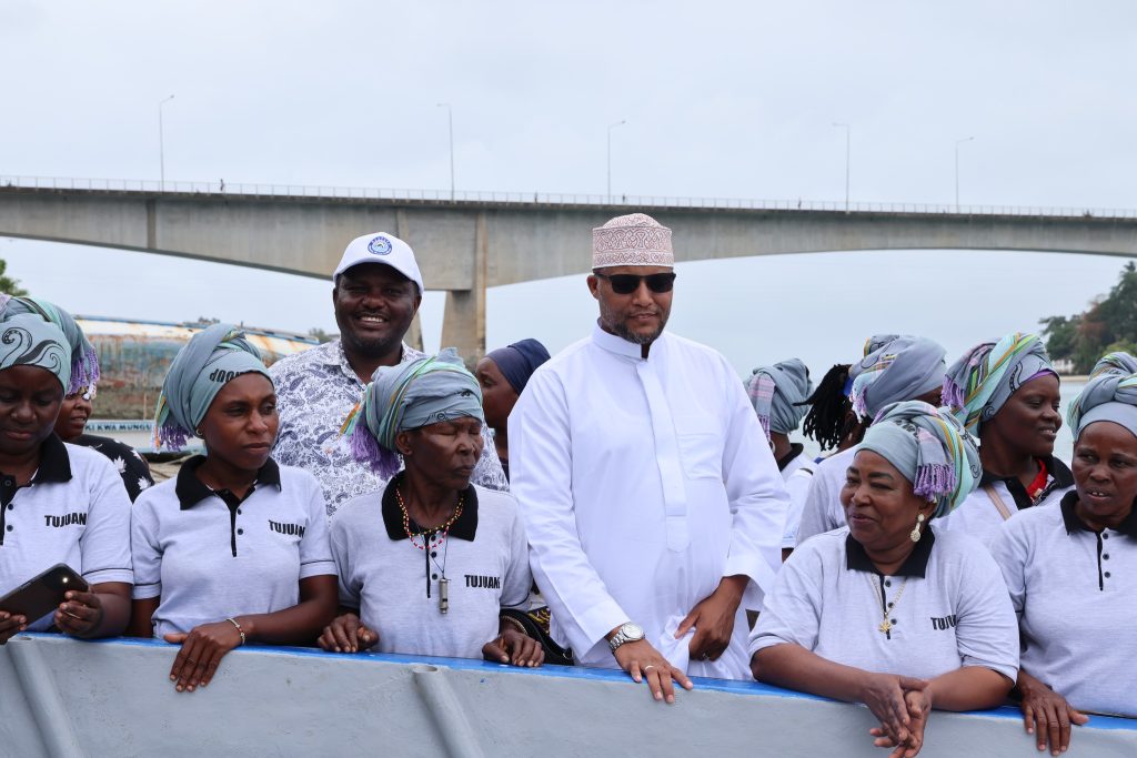 Lamu CEC for fisheries Faiz Fankupi views joins members of Pweza women's group to view their new boat acquired with a KEMFSED grant