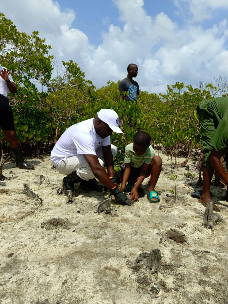 KEMFSED National Project Coordinator Patrick Kiara joins the community in a mangrove tree-planting event at Sita Landing Site in Kilifi